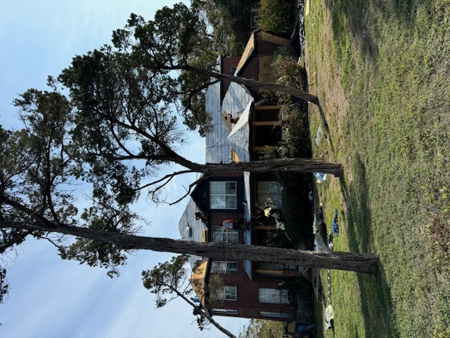 Mid-project roof with exposed deck and tarp after storm damage